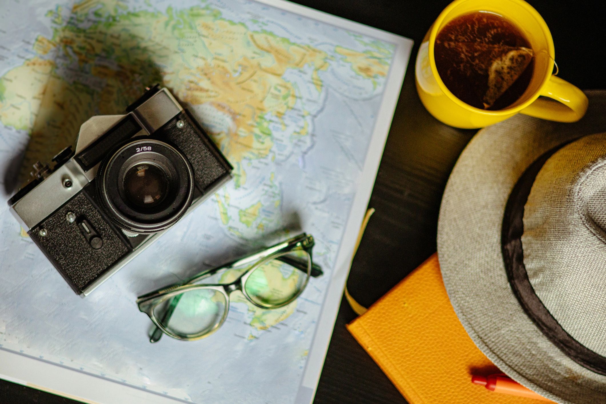 Travel planning flat lay with map and camera
